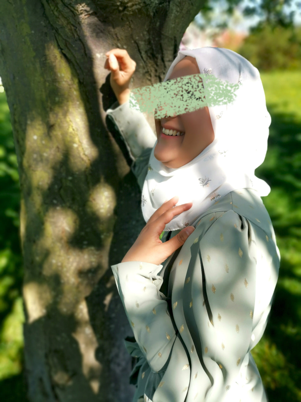 Person wearing a white hijab and light-colored outfit in a natural setting